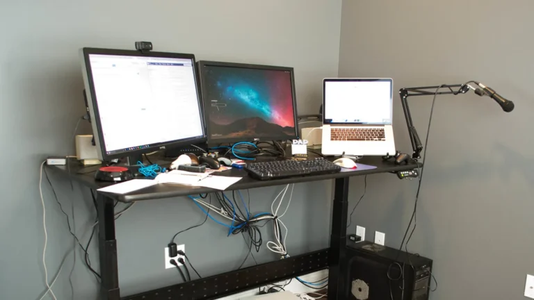 Condenser microphone on a boom arm with headphones on an ordinary desk.